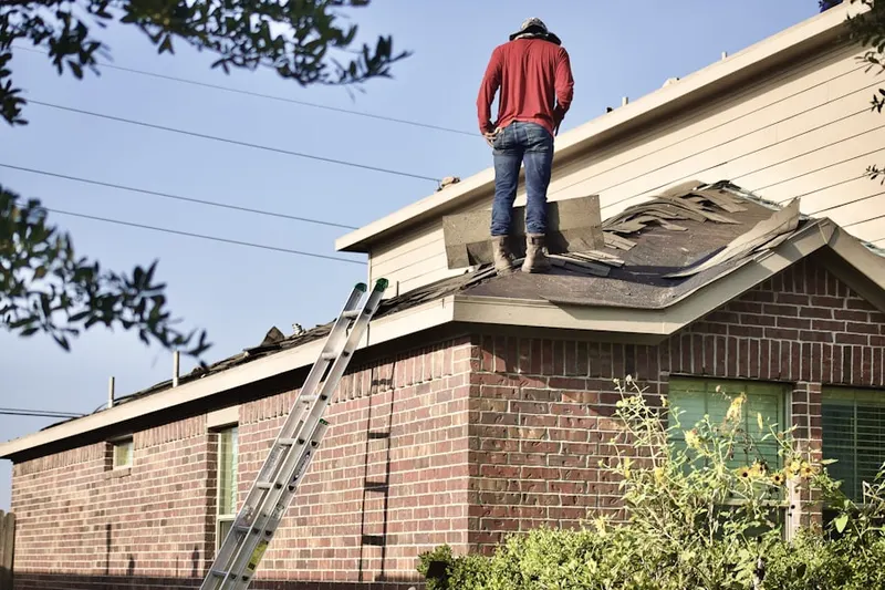 Professional roofer working on a residential roof in Earlimart
